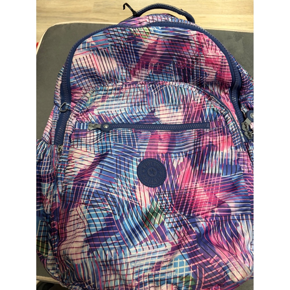 Kipling Seoul Go backpack featuring a "Radiant Splash" geometric pattern. Purple